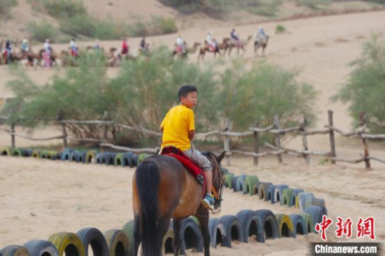 小朋友在宁夏黄沙古渡原生态景区体验骑马。　于晶 摄